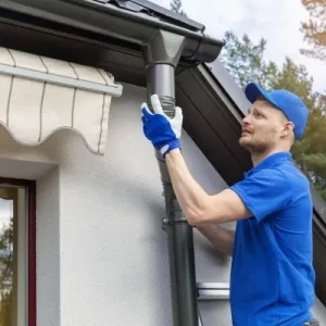 Gutter professional fits downspout onto gutter