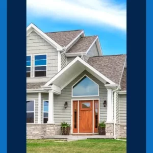 A two-story home with a brown shingled roof, white siding, stone accents, and a red front door.