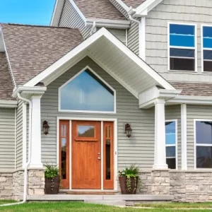 Beautiful two-story house with white gutters installed along the roofline, enhancing curb appeal and functionality.