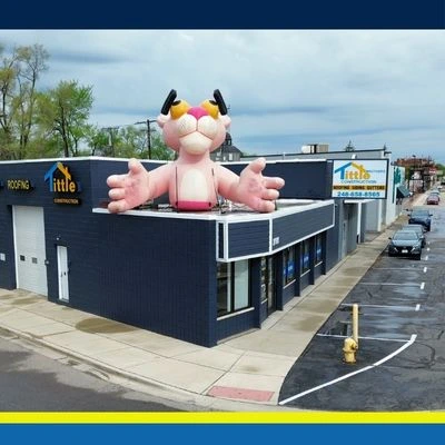 pink-panther-roofing-mascot Aerial view of Tittle Brothers Construction roofing headquarters featuring large Pink Panther mascot on building corner.