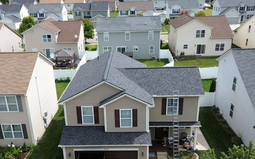 Aerial view of a residential home with a newly replaced shingle roof.